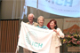 ICH旗が、グウィネス・エヴァン　ホメオパシー国際評議会（ICH）会長から、初回開催国　日本の由井寅子JPHMA会長に手渡されました。
